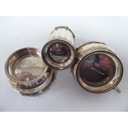 257 - Silver collectables: to include a three piece condiments set with Celtic band ornament; and a pair o... 