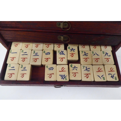 261 - A Mah Jong set with engraved bone sticks and tiles  (completeness not guaranteed) contained in ... 