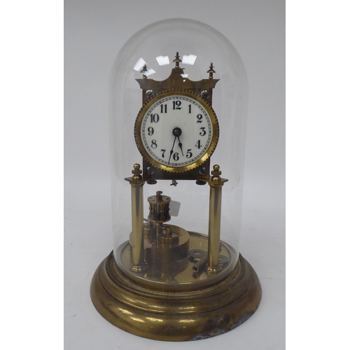 272 - A German made, lacquered brass cased torsion timepiece, the exposed movement on twin pillars, faced ... 