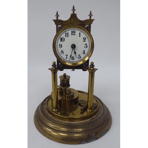 272 - A German made, lacquered brass cased torsion timepiece, the exposed movement on twin pillars, faced ... 