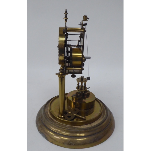 272 - A German made, lacquered brass cased torsion timepiece, the exposed movement on twin pillars, faced ... 