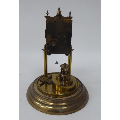 272 - A German made, lacquered brass cased torsion timepiece, the exposed movement on twin pillars, faced ... 