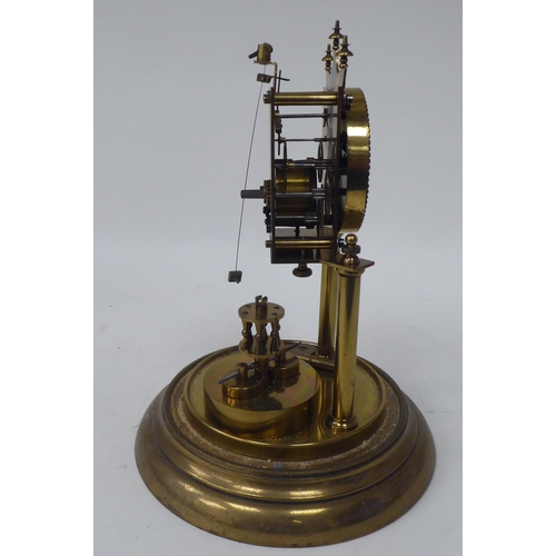 272 - A German made, lacquered brass cased torsion timepiece, the exposed movement on twin pillars, faced ... 