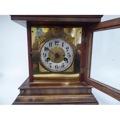 274 - An early 20thC walnut veneered cased bracket clock with brass mounts and a folding top handle; the m... 