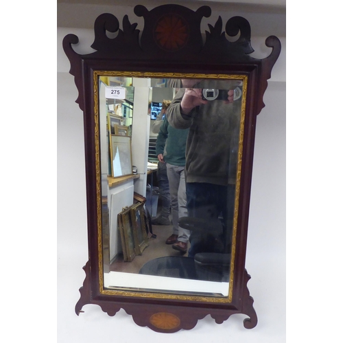 275 - An early 20thC Chippendale inspired bevelled mirror, set in a fretworked mahogany framed with fan ma... 