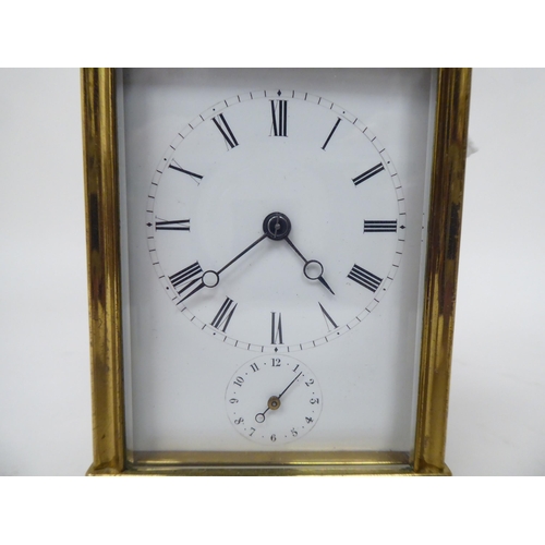 47 - A late 19thC lacquered brass cased carriage timepiece with bevelled glass panels; the movement faced... 