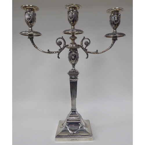 64 - An Edwardian loaded silver two part table candelabrum of Neo Classical design, comprising three vase... 