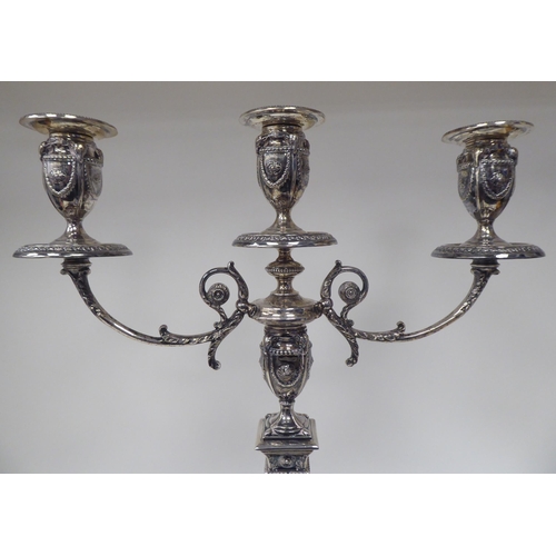 64 - An Edwardian loaded silver two part table candelabrum of Neo Classical design, comprising three vase... 