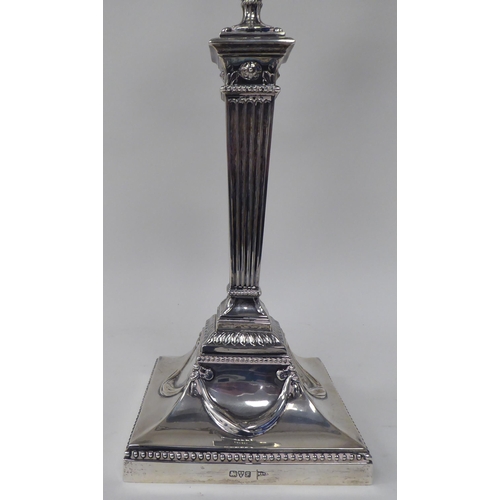 64 - An Edwardian loaded silver two part table candelabrum of Neo Classical design, comprising three vase... 