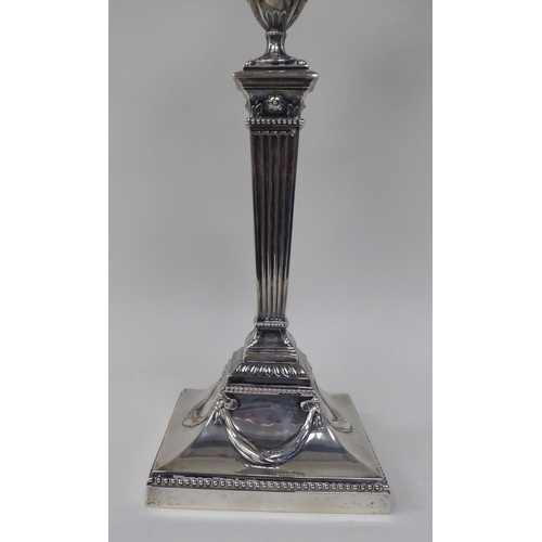 64 - An Edwardian loaded silver two part table candelabrum of Neo Classical design, comprising three vase... 