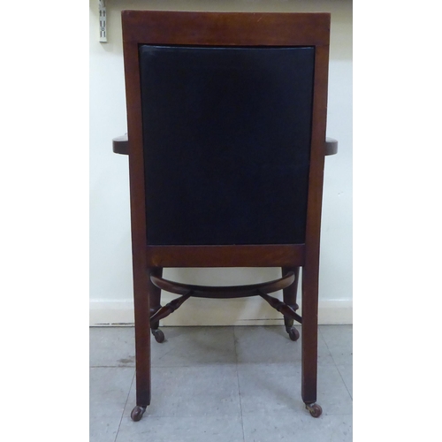 7 - A late Victorian mahogany framed desk chair, the back with a blue hide, button upholstered panel, ov... 