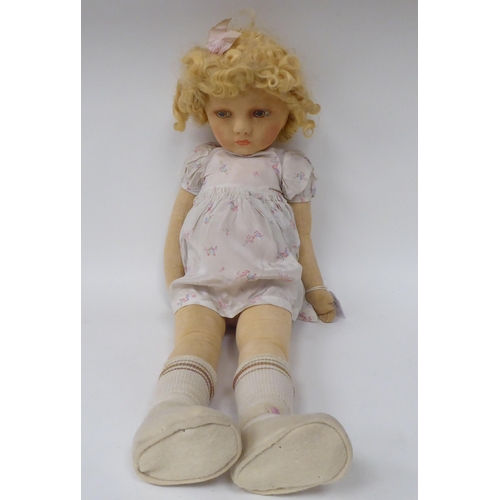 77 - An early 20thC doll, the moulded and painted head on a fabric body  27