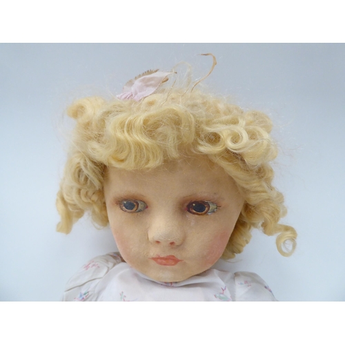 77 - An early 20thC doll, the moulded and painted head on a fabric body  27