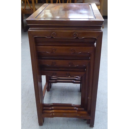 87 - Modern Asian carved teak quartetto tables with panelled and mitred tops, raised on moulded square le... 