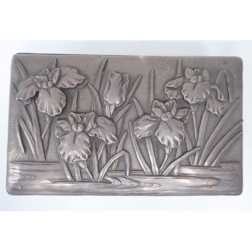 90 - An early 20thC Chinese silver coloured metal clad, hardwood cigarette box, embossed in Sino-European... 