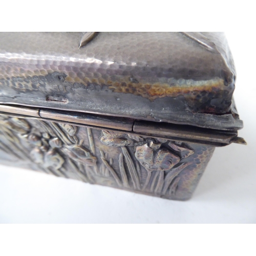 90 - An early 20thC Chinese silver coloured metal clad, hardwood cigarette box, embossed in Sino-European... 