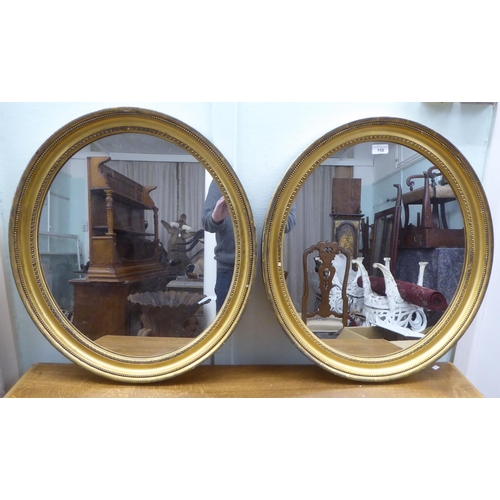 150 - A pair of 19thC oval mirrors, set in egg and dart and bead moulded gilt frames  25