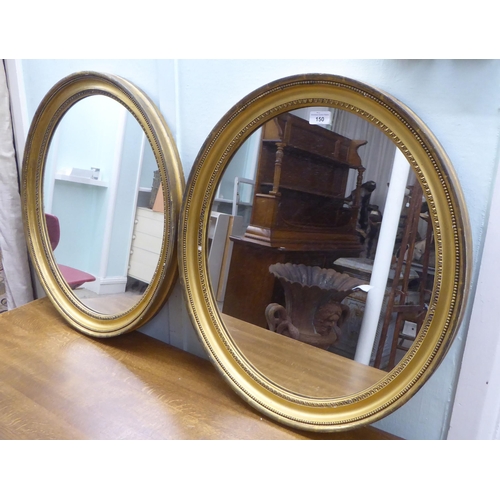 150 - A pair of 19thC oval mirrors, set in egg and dart and bead moulded gilt frames  25