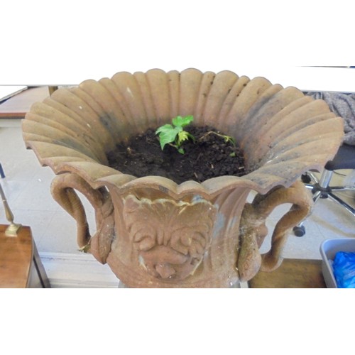 89 - A cast iron terrace urn with a flared rim, opposing ring handles and masks, on a pedestal foot  30