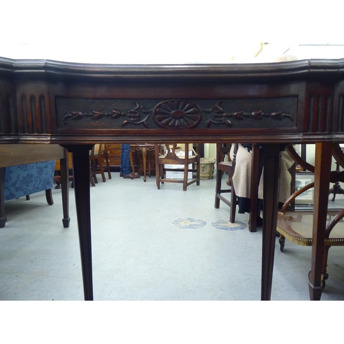 101 - An Edwardian mahogany kidney shape occasional table with a carved apron, raised on square, tapered l... 