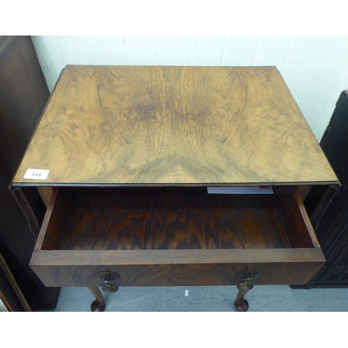 111 - A 1930s Pembroke style walnut finished, butterfly top side table with a frieze drawer, raised on sle... 