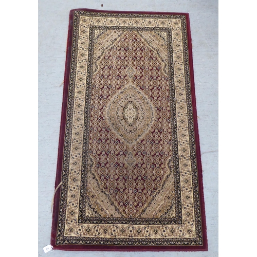 128 - A modern Persian woollen rug, decorated in colours  59