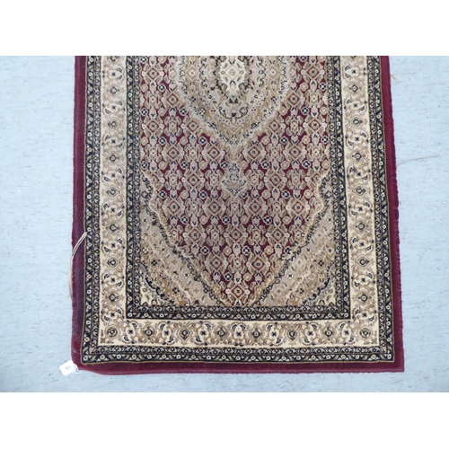 128 - A modern Persian woollen rug, decorated in colours  59