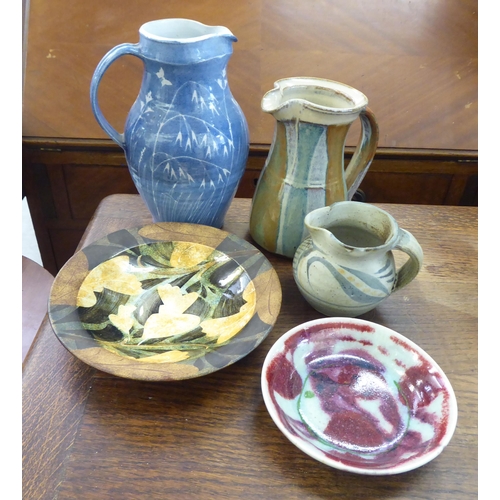 135 - Five items of studio pottery: to include a dish, decorated in colours with autumnal designs  bears a... 