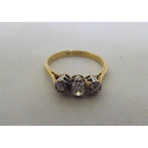 174 - An 18ct gold and platinum three stone diamond ring