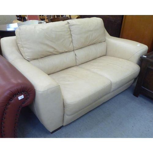 179 - A modern two person cream coloured hide upholstered settee