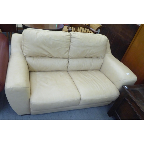 179 - A modern two person cream coloured hide upholstered settee