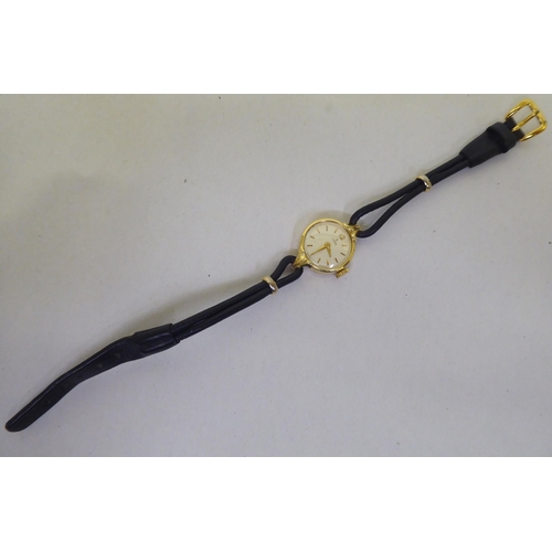 181 - A lady's Tudor 18ct gold cased wristwatch, faced by a baton dial, on a black hide strap