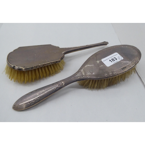 183 - Two silver backed dressing table hair brushes  mixed marks