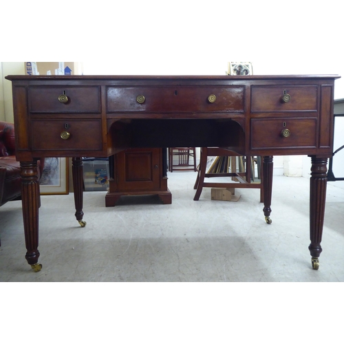 200 - A late Victorian mahogany kneehole five drawer writing table with a low part gallery border, raised ... 