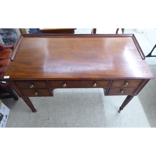 200 - A late Victorian mahogany kneehole five drawer writing table with a low part gallery border, raised ... 