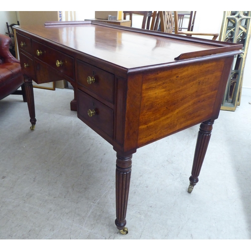 200 - A late Victorian mahogany kneehole five drawer writing table with a low part gallery border, raised ... 