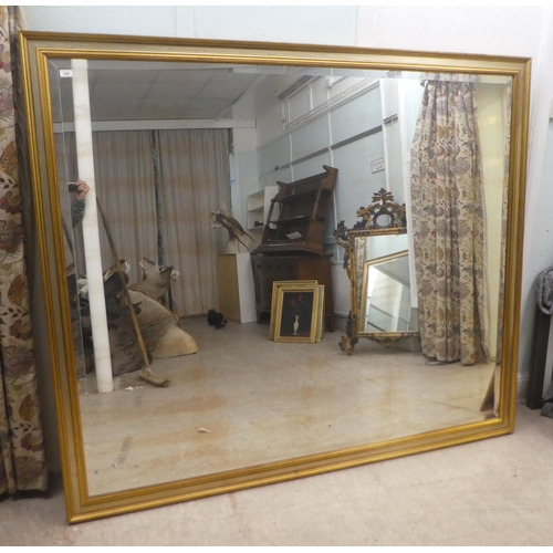 226 - A modern mirror, the bevelled plate set in a moulded and silvered gilt frame  66