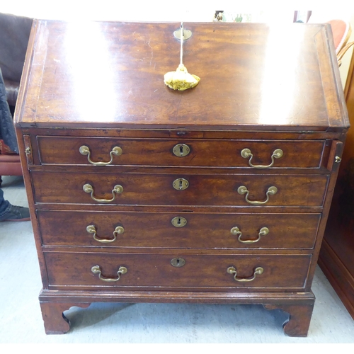 243 - A George III mahogany bureau, the fall-flap over four graduated drawers, raised on bracket feet ... 