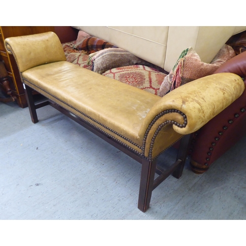 263 - An early 20thC window seat, stud upholstered in sun bleached brown hide, raised on square legs  54