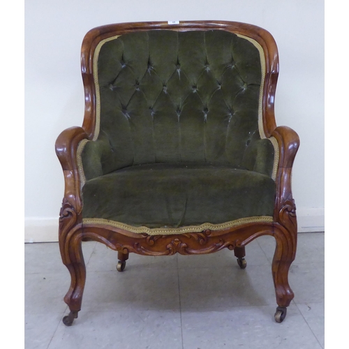 269 - A mid 19thC walnut framed salon chair with a button upholstered green fabric back, raised on cabriol... 