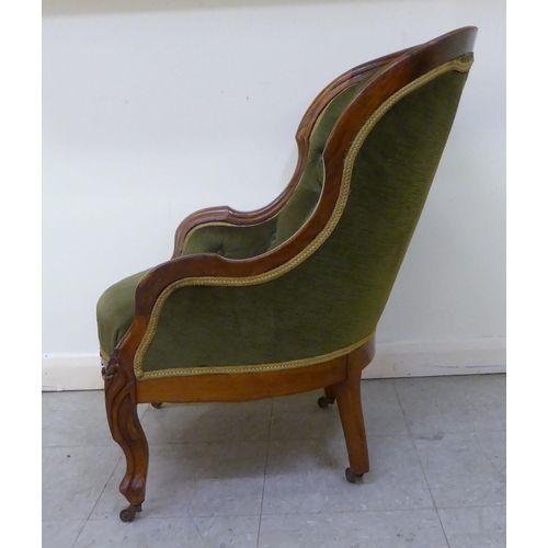 269 - A mid 19thC walnut framed salon chair with a button upholstered green fabric back, raised on cabriol... 