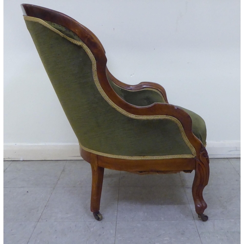 269 - A mid 19thC walnut framed salon chair with a button upholstered green fabric back, raised on cabriol... 