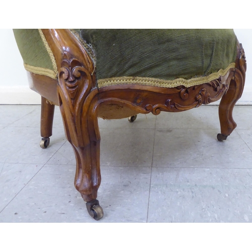 269 - A mid 19thC walnut framed salon chair with a button upholstered green fabric back, raised on cabriol... 