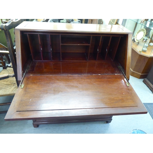 282 - A modern Chinese fruitwood bureau with a fall flap, over two short/two long drawers, raised on block... 