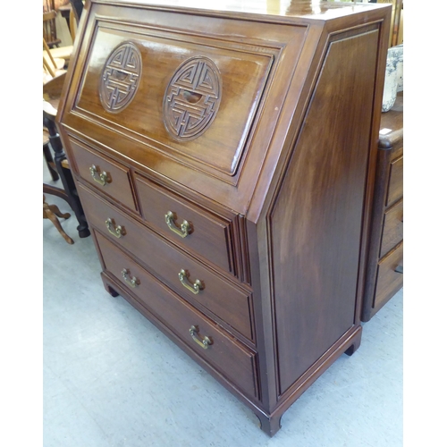 282 - A modern Chinese fruitwood bureau with a fall flap, over two short/two long drawers, raised on block... 