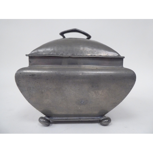 285 - An English Pewter caddy of square outline with a bulbous body, cover and top handle, on bun feet  im... 