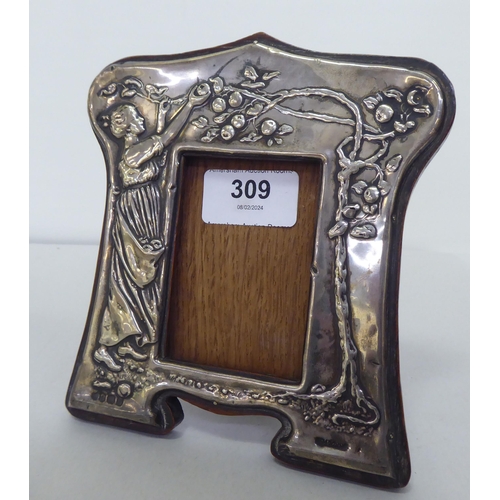 309 - An early 20thC Art Nouveau silver mounted photograph frame, embossed with a woman picking apples fro... 