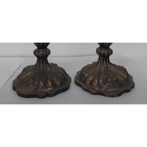 317 - A pair of late 19thC Continental white metal candlesticks, each with a reeded column, on a circular ... 