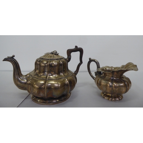 322 - A late 19thC Continental white metal teapot and milk jug of pedestal, ribbed design