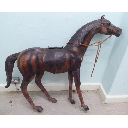 325 - A burnished and moulded hide standing, saddled and bridled model horse  approx. 37